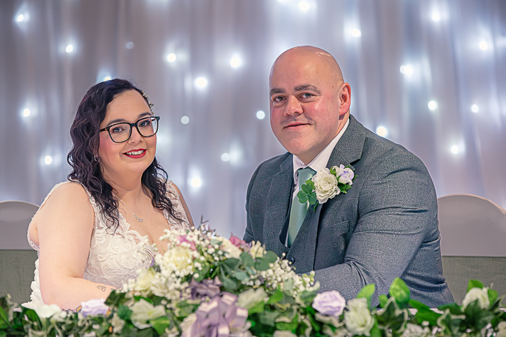 bride and groom seating at the wedding table after signing the register.