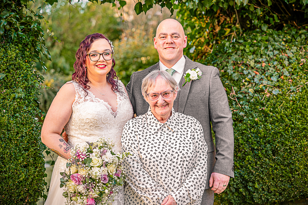 Bride, Groom and nanna under a leaf shaped arch taken by Manchester Photographer Wedding Rebekah Morecroft