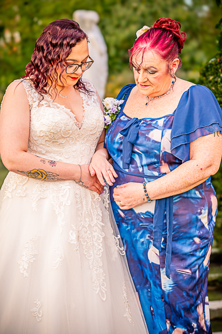 Bride holding hand out to show mother of the bride her wedding ring