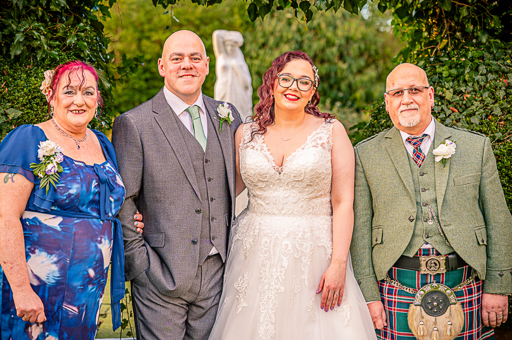 Bride and Groom with Brides parents under a leaf shaped arch taken by Manchester Photographer Wedding Rebekah Morecroft