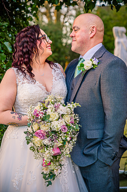 Bride and Groom looking at each other with a leaf shaped arch behind them taken by Manchester Photographer Wedding Rebekah Morecroft