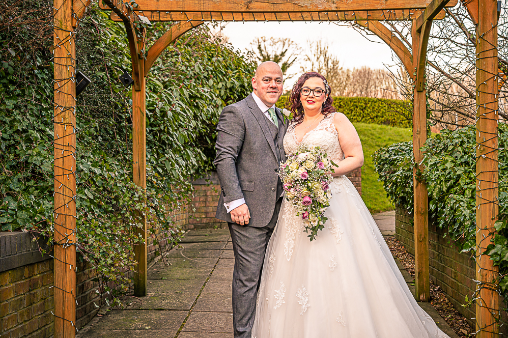 Bride and Groom standing under a gazebo