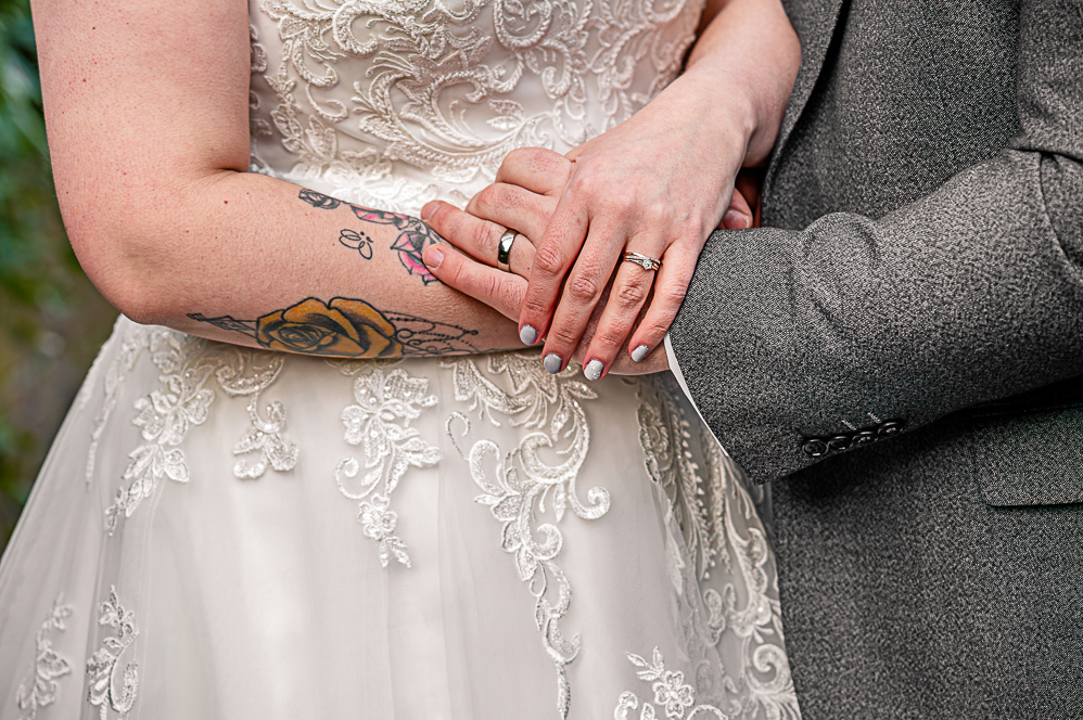 Close up the bride and grooms arms and hands overlapping
