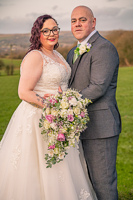 Bride and Groom holding each other with hills behind them.