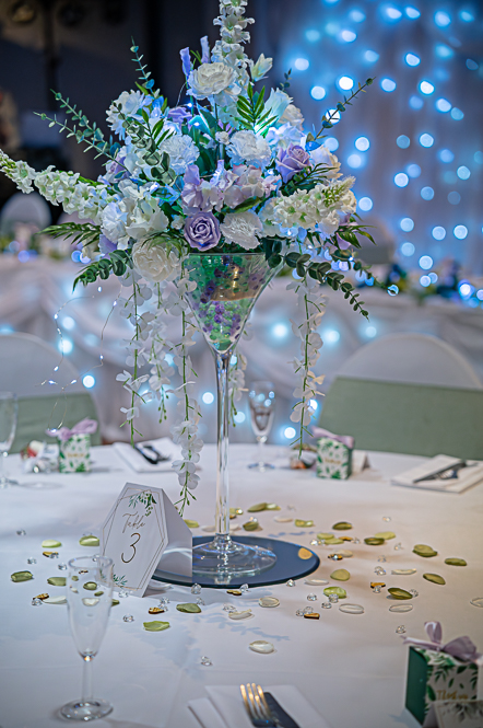 Wedding table decorations with large martini glass with flowers inside as centre piece
