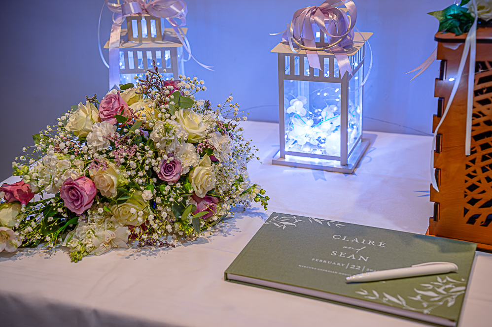 Wedding latents with lights inside, brides flowers and couples signing booking.