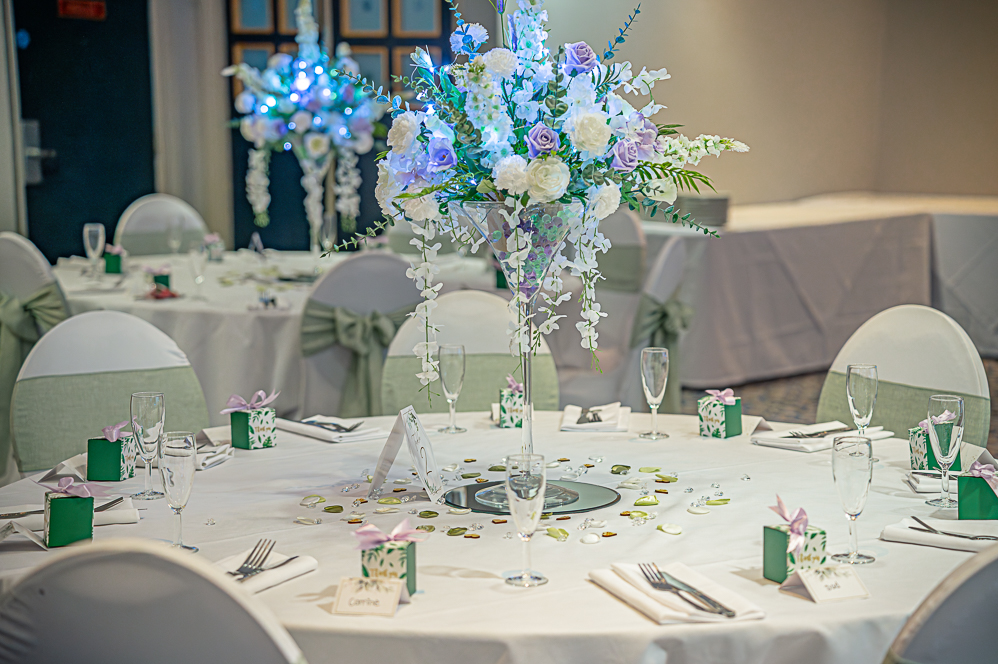 Wedding table decorations with large martini glass with flowers inside as centre piece