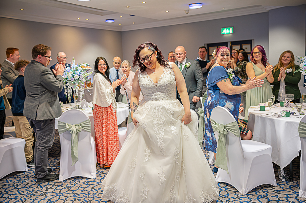 Bride and Groom entering the reception as guests stand and clap them.