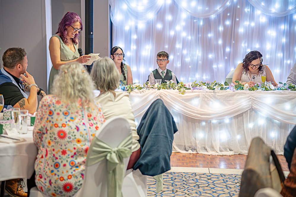 View of wedding guests listening to maid of honour giving a speech
