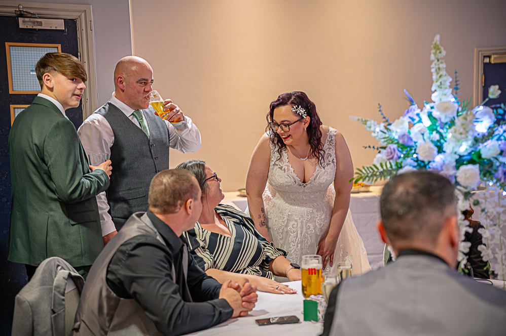 Group of wedding guests chatting to bride and groom