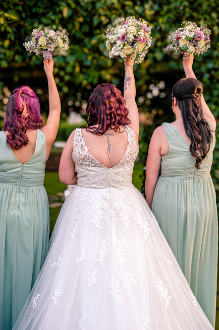 Bride and 2 bridesmaids from behind with bouquets in the air taken by Manchester Photographer Wedding Rebekah Morecroft