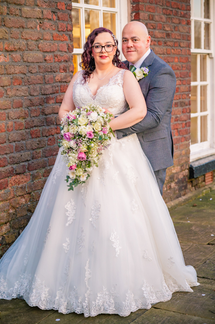 Bride and groom standing in front of Georgian style building