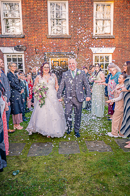 Joyful newlywed couple covered in confetti celebrating their wedding day in Manchester