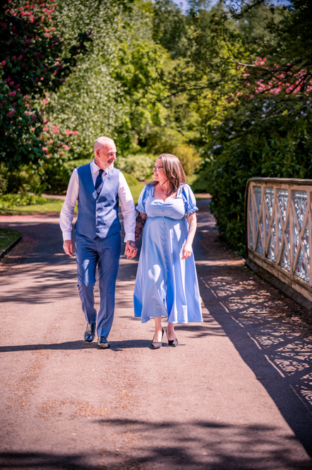 Couple holding hands walking across a bridge