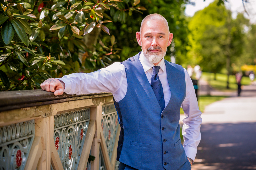 Man leaning on the side of a bridge