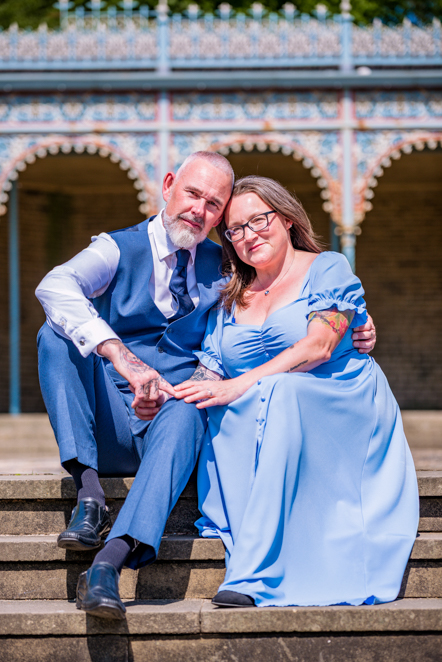 Couple sitting closely together holding hands on some steps taken by Manchester Photographer Wedding Rebekah Morecroft