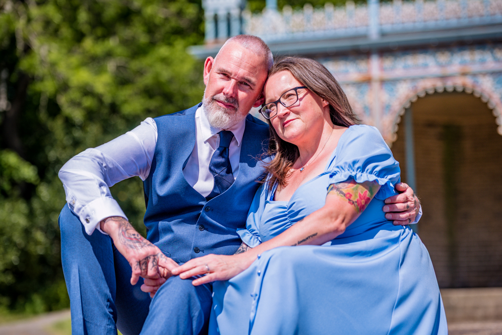 Couple sitting closely together holding hands on some steps
