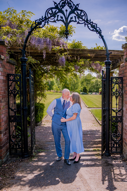 Couple standing in front Iron arch with noses touching