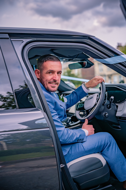 Groom sitting in the driver seat of the Range Rover