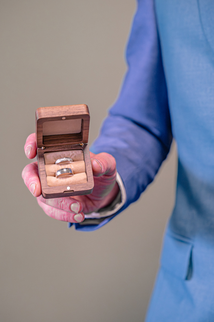 Close-up of the wedding rings in the wedding box being held by the groom