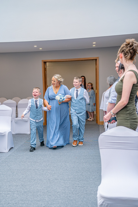 Bridesmaids walking down the aisle with two page boys