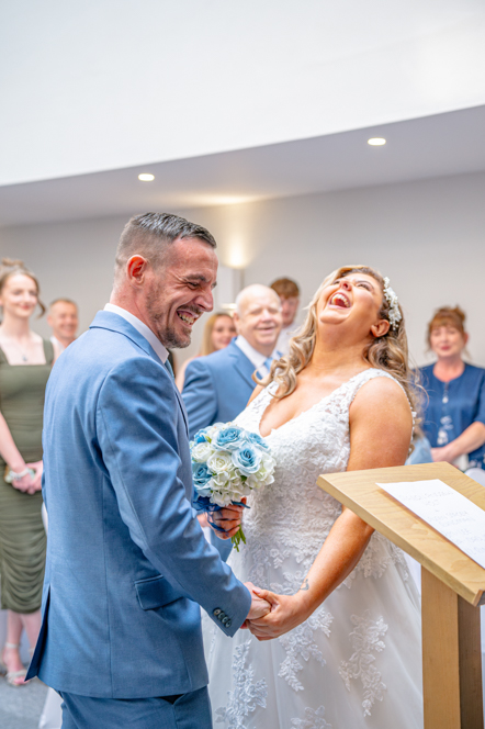 The bride and groom holding hands while laughing