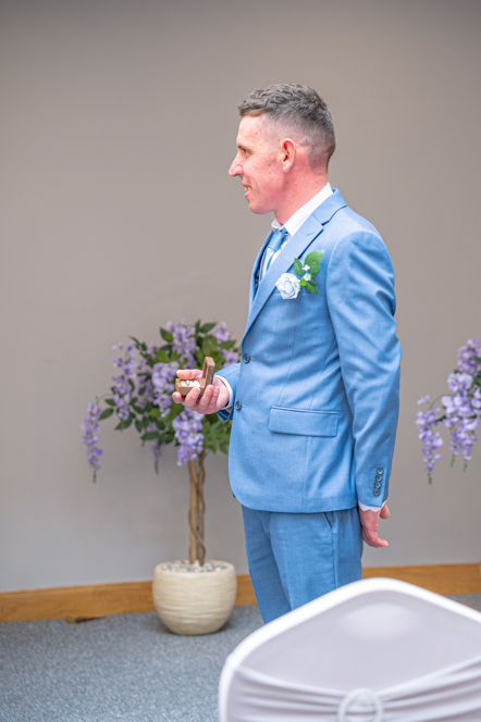 Best man holding the rings with the box open