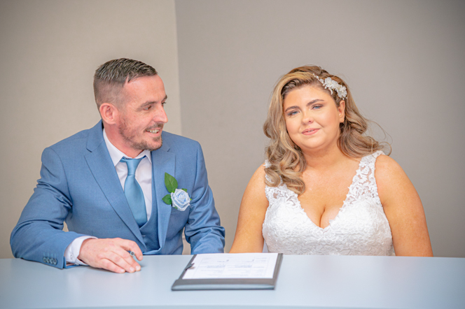 Groom looking at bride after signing the register