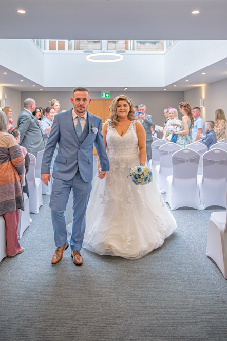Bride and groom walking up the aisle together after the ceremony, Bury registry office
