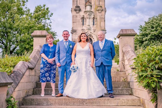 Bride and groom with the bride's parents on the steps at The Whitehead Clock Tower, Bury