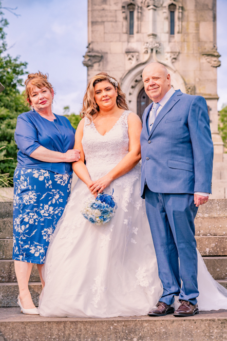Bride with her parents standing on some steps