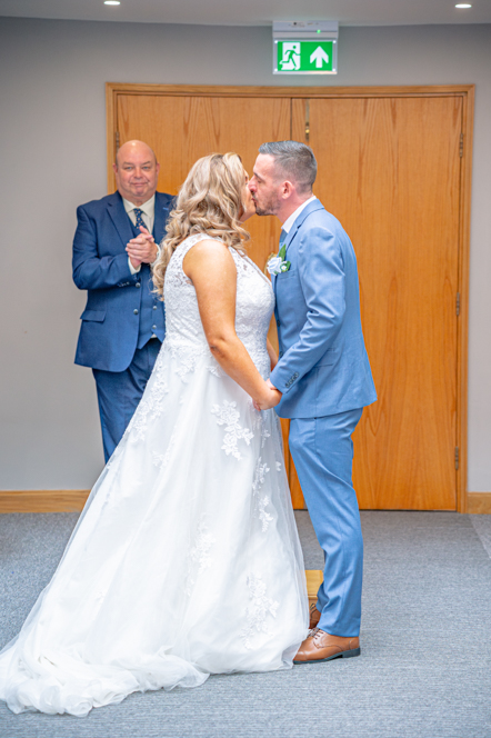 Couple sharing their first kiss at Bury Town Hall wedding ceremony.