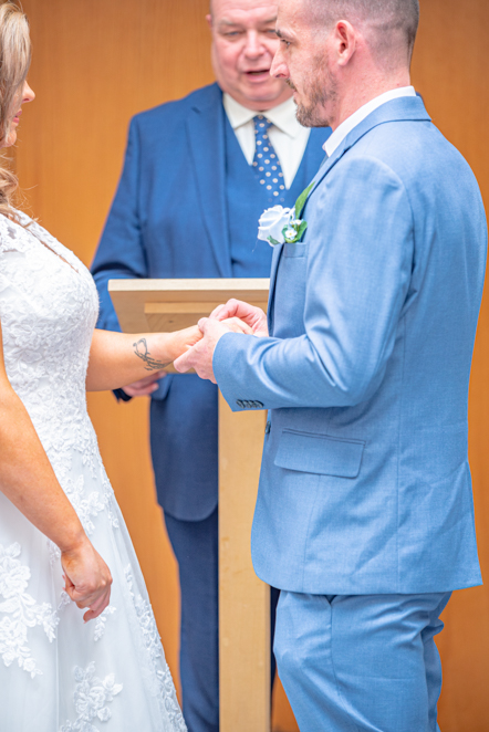 Couple exchanging rings during their wedding ceremony at Bury Town Hall.