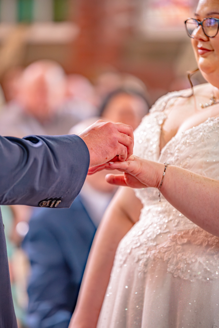 Groom placing ring on brides hand