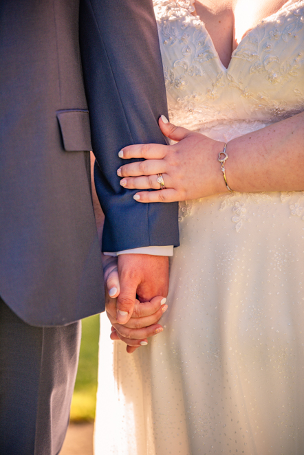 Close up at bride and groom holding hands