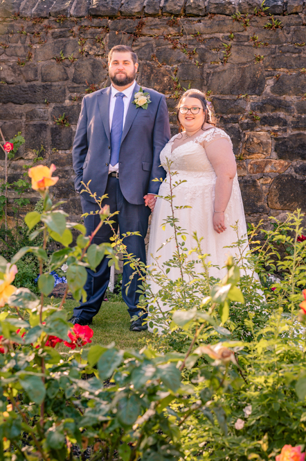 Bride and groom holding hands with flowers in the foreground