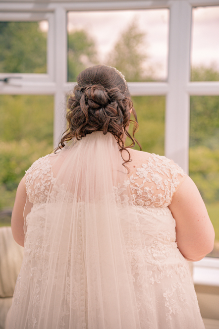 Back view of the bride's dress, hair, and veil ahead of her Metro Christian Centre wedding