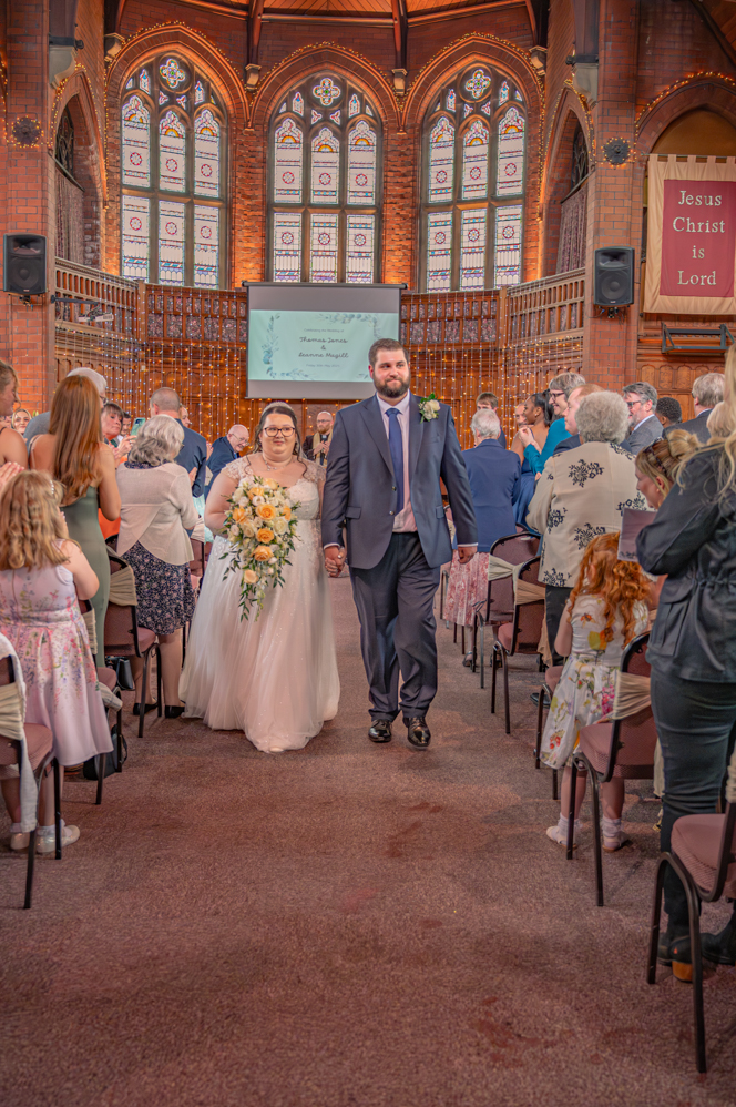 Bride and groom walking up the aisle after ceremony in Bury