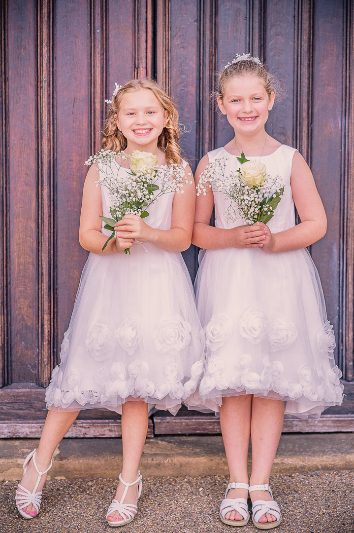Two flower girls holding their bouquets.