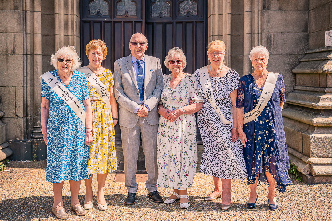 Older couple with four ladies outside St Peter’s Church, Ashton-under-Lyne, after traditional Christian wedding vow renewal