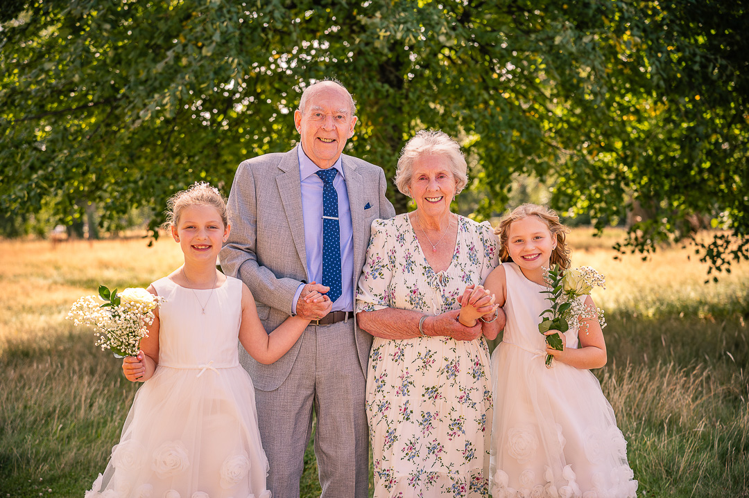 Older couple with two flower girls at St Peter’s Church, Ashton-under-Lyne, traditional Christian wedding vow renewal