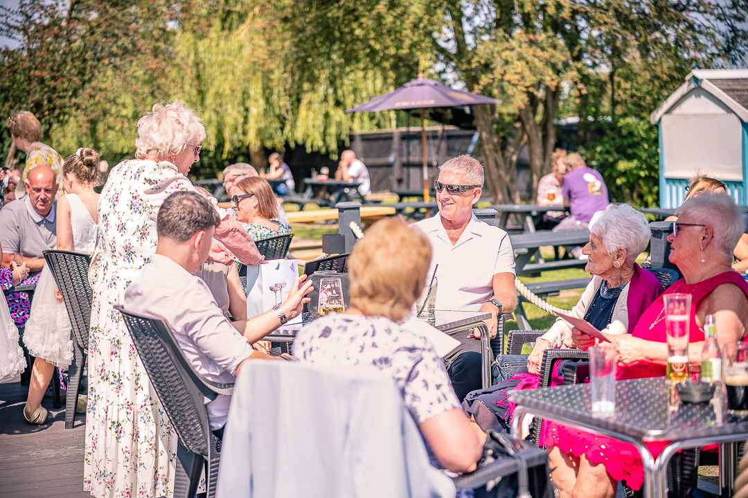 Friends and family socialising outdoors at a vow renewal celebration.
