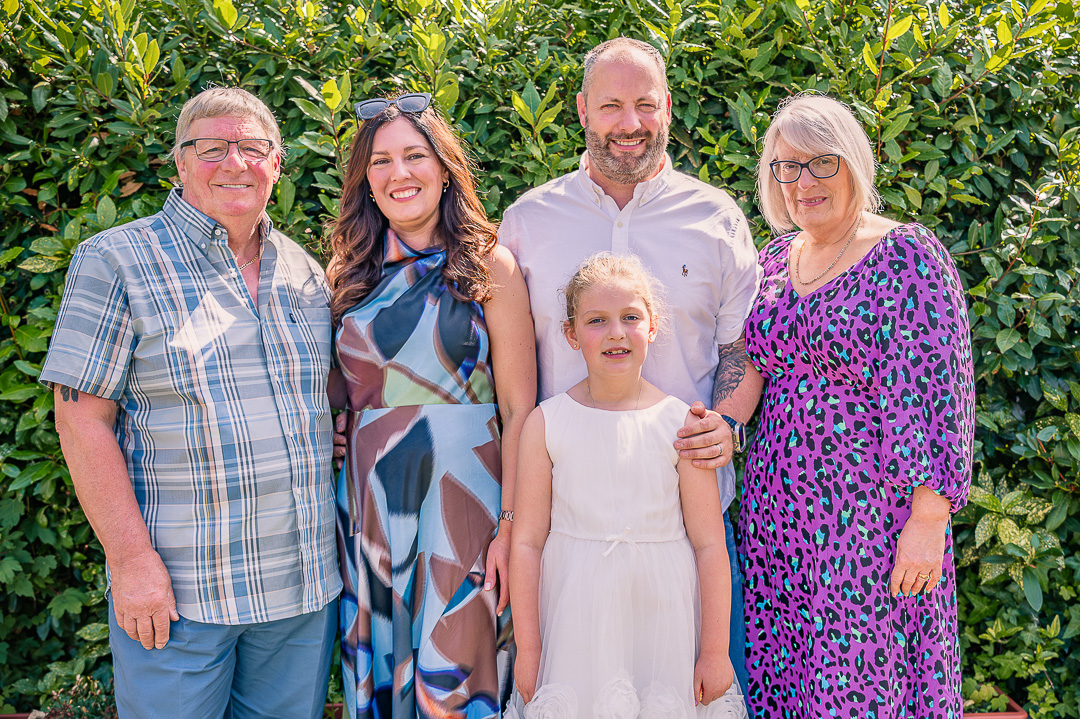 Parents posing with their son, daughter-in-law and granddaughter at the reception.