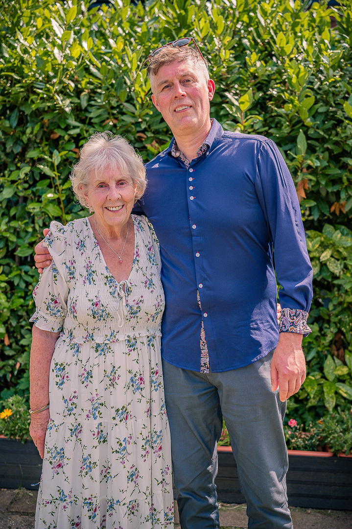 Elderly grandmother posing with her adult grandson at the reception.
