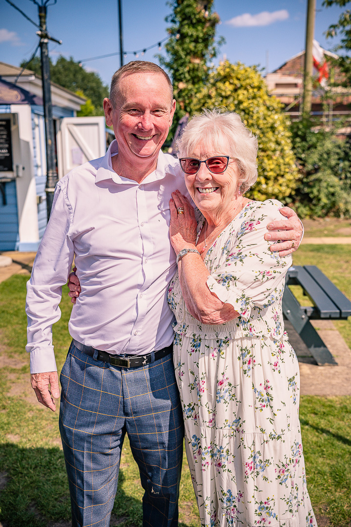 Portrait of a man standing beside an elderly woman at the reception.