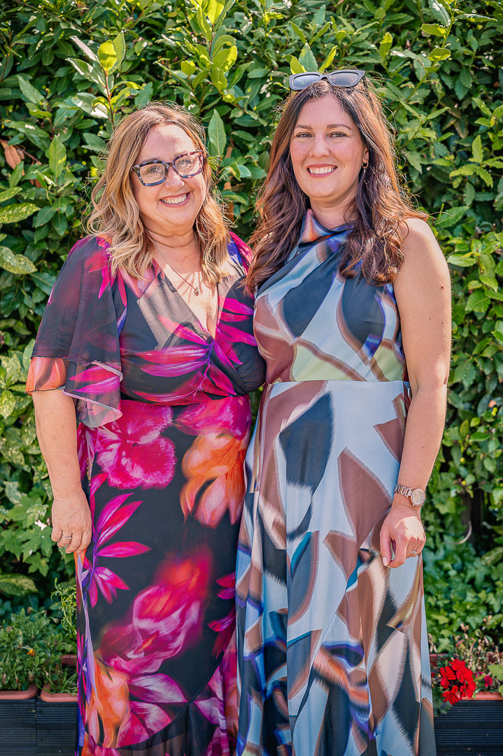 Two women standing together for a portrait at the reception.