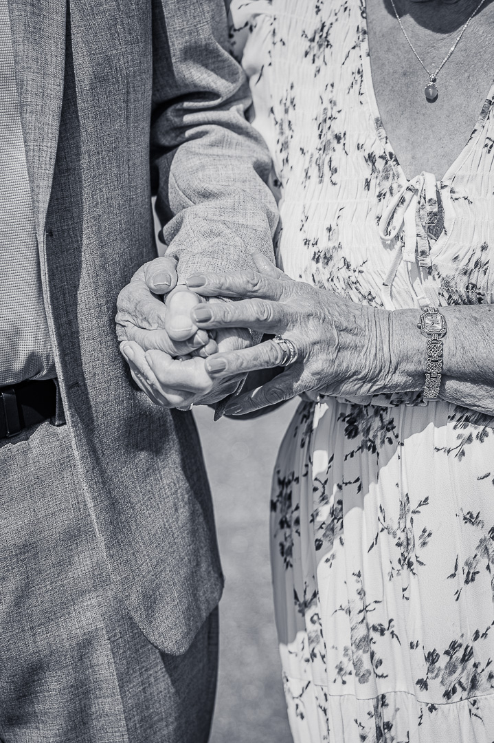 Black and white portrait capturing 70 years of marriage through joined hands