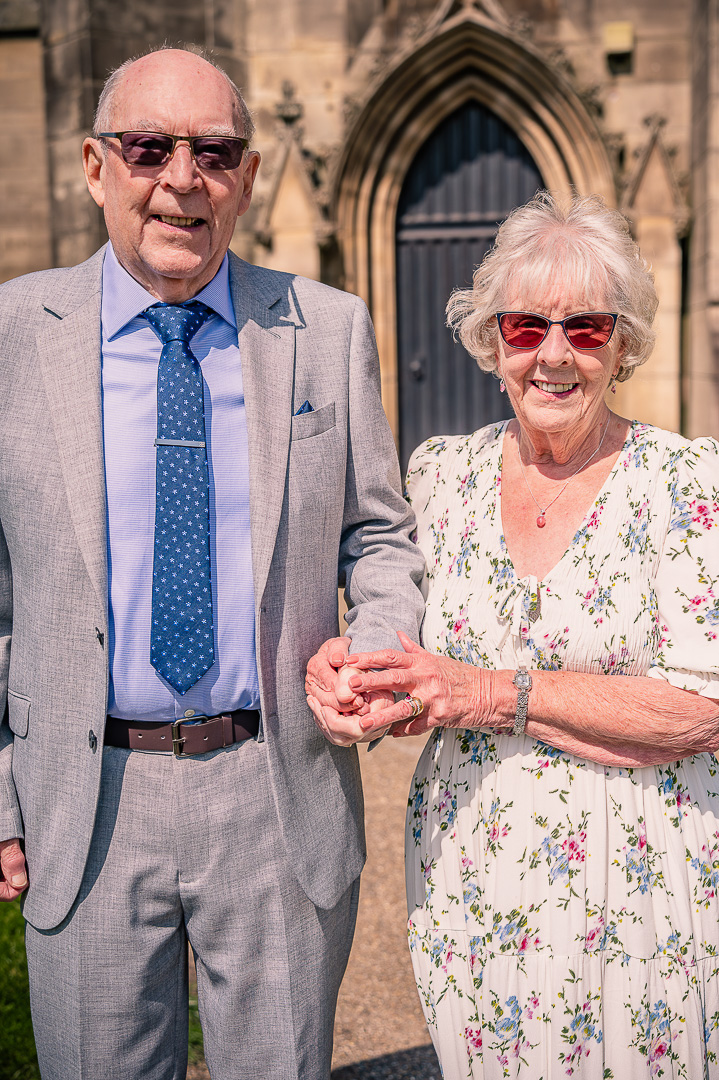 Dennis and Patricia holding hands at St Peter’s Church, Ashton-under-Lyne, traditional Christian wedding vow renewal