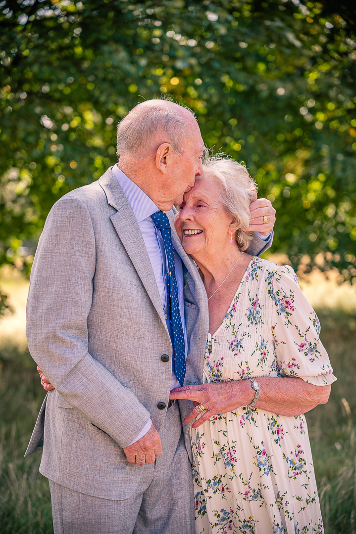 Dennis kissing Patricia’s head outside St Peter’s Church, Ashton-under-Lyne, traditional Christian wedding vow renewal
