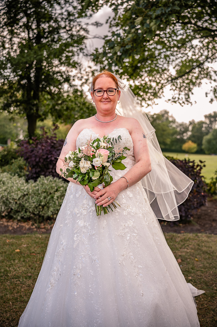 Portrait of the bride among the trees at Broadfield Park in Rochdale